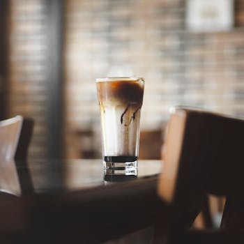 Close-up of iced coffee in a glass on a table in a cozy café.