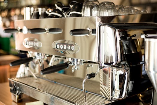 A sleek and modern stainless steel coffee machine in a contemporary cafe setting.