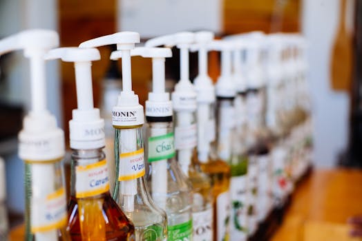 Row of coffee syrup pumps in various flavors, ideal for cafes.